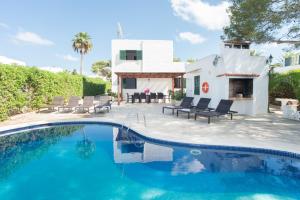 a swimming pool in front of a house at Villa Dos Pinos in Cala d´Or