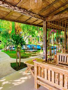 a wooden bench under a pavilion in a park at Oasis Villas in Gili Trawangan