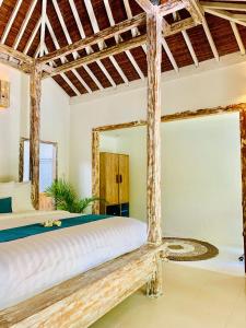 1 dormitorio con cama y espejo grande en Oasis Villas, en Gili Trawangan
