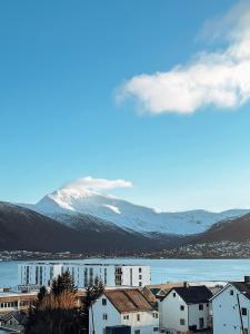 a view of a town with a snowy mountain at Penthouse apartment with amazing view. in Tromsø