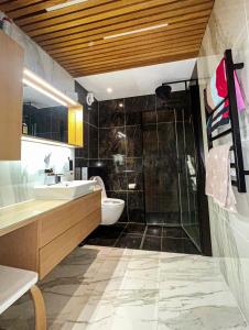 a bathroom with a shower and a sink and a toilet at Penthouse apartment with amazing view. in Tromsø