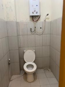 a bathroom with a white toilet in a stall at Hotel Puspa Sari in Ciater