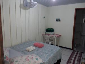 a small room with a bed and a table at Pousada Praia Mansa Superagui in Superagui