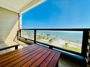 einen Balkon mit einer Holzbank und Strandblick in der Unterkunft Garden Sea in Phu Quoc