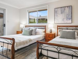 a bedroom with two beds and a window at 3A Kunama in Berridale