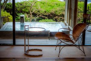 two chairs and a table in front of a pool at Hotel Kitanoya in Miyazu