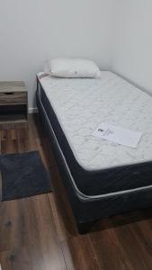 a bed sitting on a wooden floor next to a table at Cerca Reloj Flores Viña in Viña del Mar