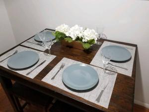 a wooden table with plates and glasses on it at Pet Friendly Apartment minutes from NYC! in West New York