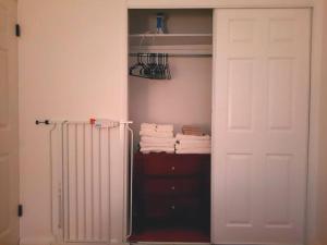 um armário com uma porta branca e algumas toalhas em Pet Friendly Apartment minutes from NYC! em West New York