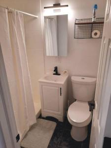 La salle de bains blanche est pourvue de toilettes et d'un lavabo. dans l'établissement Pet Friendly Apartment minutes from NYC!, à West New York