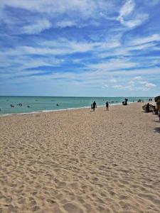 un grupo de personas en una playa con el océano en La Conchita de Sisal 1, en Sisal