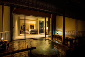 a house with a pool in the middle of a room at Hotel Kitanoya in Miyazu
