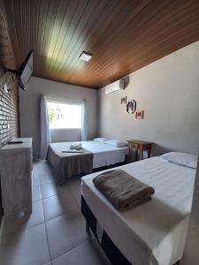 Cette chambre comprend 2 lits et une fenêtre. dans l'établissement Hotel e Pousada Pouso54, à Ubatuba