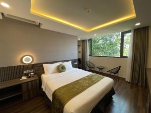 a hotel room with a large bed and a window at 3T Hotel Hanoi in Hanoi