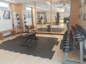 a gym with exercise equipment and a woman in a mirror at Family Staycation with Pool in Manila