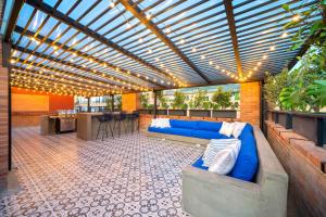 un patio con un sofá azul y una pérgola en FH - Luxury coliving in Virrey park - Bogota, en Bogotá