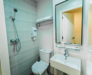 uma casa de banho com um WC, um lavatório e um espelho. em Value Hotel Nice em Singapura