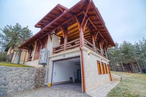 a house with a garage with a wooden roof at Bajin chalets in Dobroselica