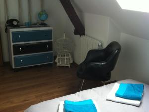 a bedroom with a black chair and a dresser at Longère sarthoise rénovée, à 20 min du Mans, 4 chambres, poêle à granulés, parking privé - FR-1-410-376 in Connerré +6 photos