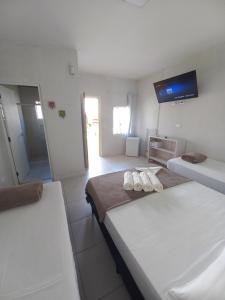 um quarto com duas camas e uma televisão na parede em Hotel e Pousada Pouso54 em Ubatuba
