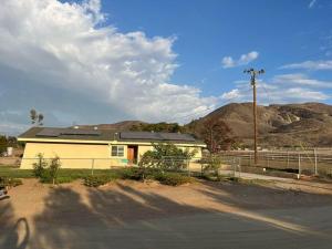 a yellow house with a fence and mountains in the background at Peaceful & Cozy 3 bedroom Ranch-Home w/Fireplace in Hemet