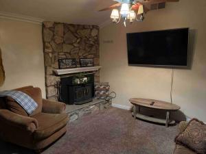 sala de estar con chimenea y TV de pantalla plana en Peaceful & Cozy 3 bedroom Ranch-Home w/Fireplace en Hemet