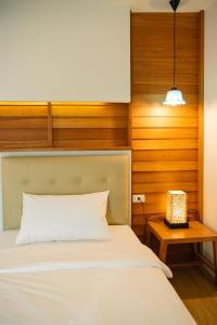 a bedroom with a bed and a night stand with a lamp at Cozy House City center BTS&MRT in Bangkok