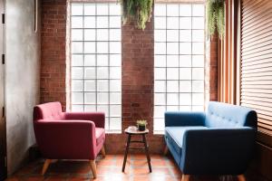 two chairs and a table in a room with windows at Cozy House City center BTS&MRT in Bangkok