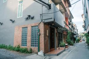 ein Backsteingebäude mit einer Katze, die davor sitzt in der Unterkunft CozyHouse near MRT QSCC Convention Center 4BR 10ppl in Bangkok