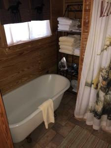 a bath tub in a bathroom with a window and towels at Country Accents - Lee Cabin in Pipe Creek