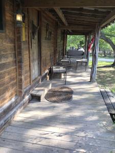 a porch of a wooden building with benches on it at Country Accents - Lee Cabin in Pipe Creek
