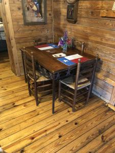 a wooden table with two chairs in a room at Country Accents - Lee Cabin in Pipe Creek