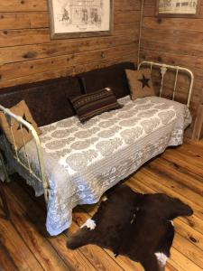 a bedroom with a bed with a black dog laying on the floor at Country Accents - Lee Cabin in Pipe Creek