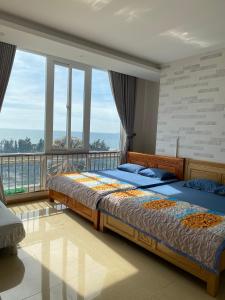 two beds in a bedroom with a balcony at Sơn Thịnh - Oasky Apartment in Vung Tau