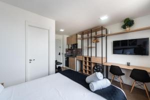 1 dormitorio con 1 cama blanca y TV en MV14 - Studio Próximo à Estação Brás: Conforto Garantido, en São Paulo