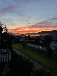 a sunset over a small town with a street at Penthouse apartment with amazing view. in Tromsø