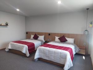 two beds in a hotel room with at Oaxaca Inn Reforma in Oaxaca City