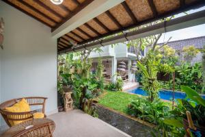 an outdoor patio with a swimming pool and a house at Angel House Ubud Eco Villa in Ubud