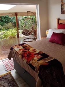 a bed in a bedroom with a view of a patio at Tortuga - Peaceful Holiday Home with Loadshedding Backup in Sedgefield