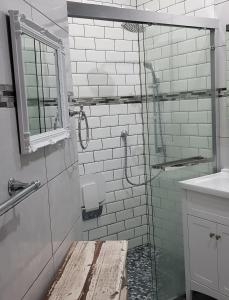 a glass shower in a bathroom with a sink at Tortuga - Peaceful Holiday Home with Loadshedding Backup in Sedgefield