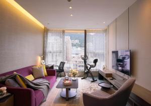 香港Oasis Aurum 181 Hotel的客厅里有一张紫色的沙发和一台电视