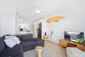 un soggiorno con divano e tavola da surf sul muro di Alfred Street - Hosted by Burleigh Letting a Gold Coast