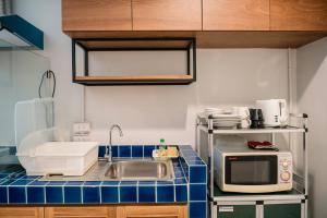 a kitchen with a sink and a microwave at Cozy House City center BTS&MRT in Bangkok