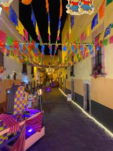 um corredor com bandeiras coloridas e luzes num edifício em Hotel Casa Santo Domingo em Zacatecas