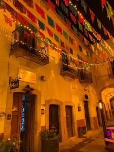 サカテカスにあるHotel Casa Santo Domingoのクリスマスの灯りと旗が掲げられた建物