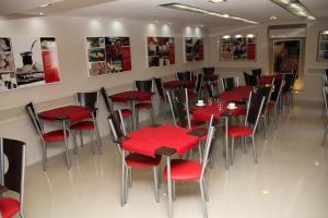 una sala da pranzo con tavoli e sedie rossi di Sol de Piedra Apart, Suites & Spa a Córdoba