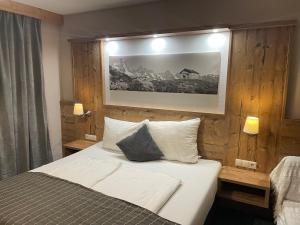 Schlafzimmer mit einem Bett mit weißer Bettwäsche und Kissen in der Unterkunft Gletscherchalet in Sankt Leonhard im Pitztal