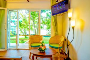a living room with two chairs and a table and a window at Kurumba Luxury Cabin in Ahangama