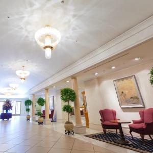 eine Lobby mit roten Stühlen und einem Kronleuchter in der Unterkunft The Saihokukan Hotel in Nagano