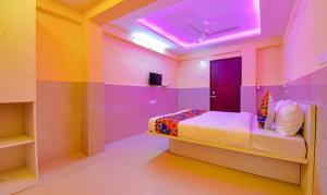 プネにあるFabHotel Empire Executiveのピンクと紫の壁のベッドルーム(ベッド1台付)